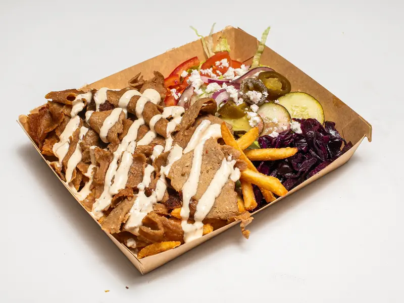 Kebabtallrik med kebab, pommes, sallad, grönsaker, jalapeños och sås